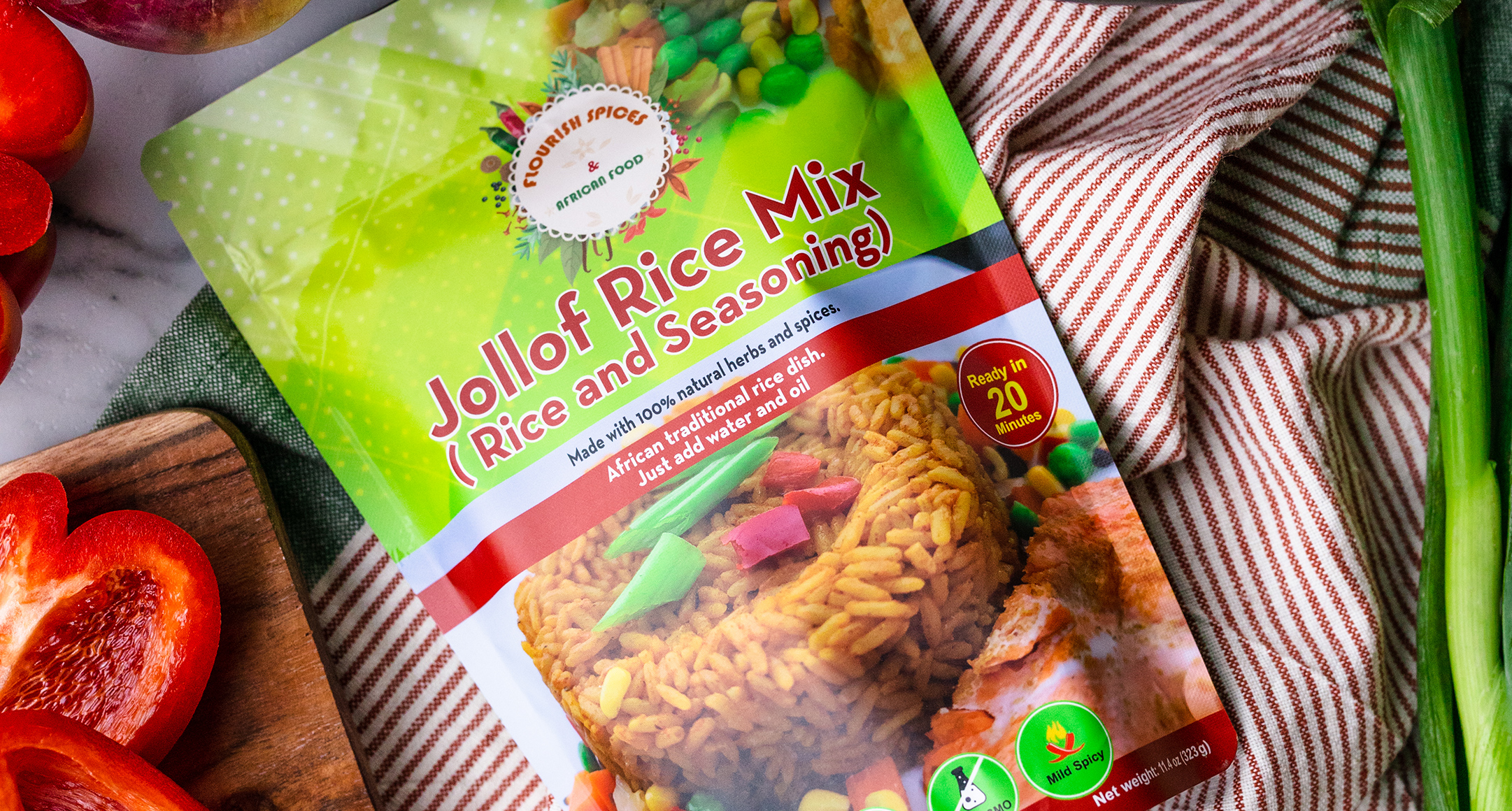 A colorful package of jollof rice mix laying on striped fabric. 