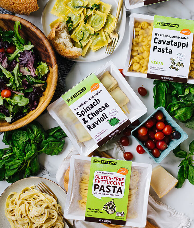 Packaged Partner Brand pasta items from New Seasons Market displayed with salad.